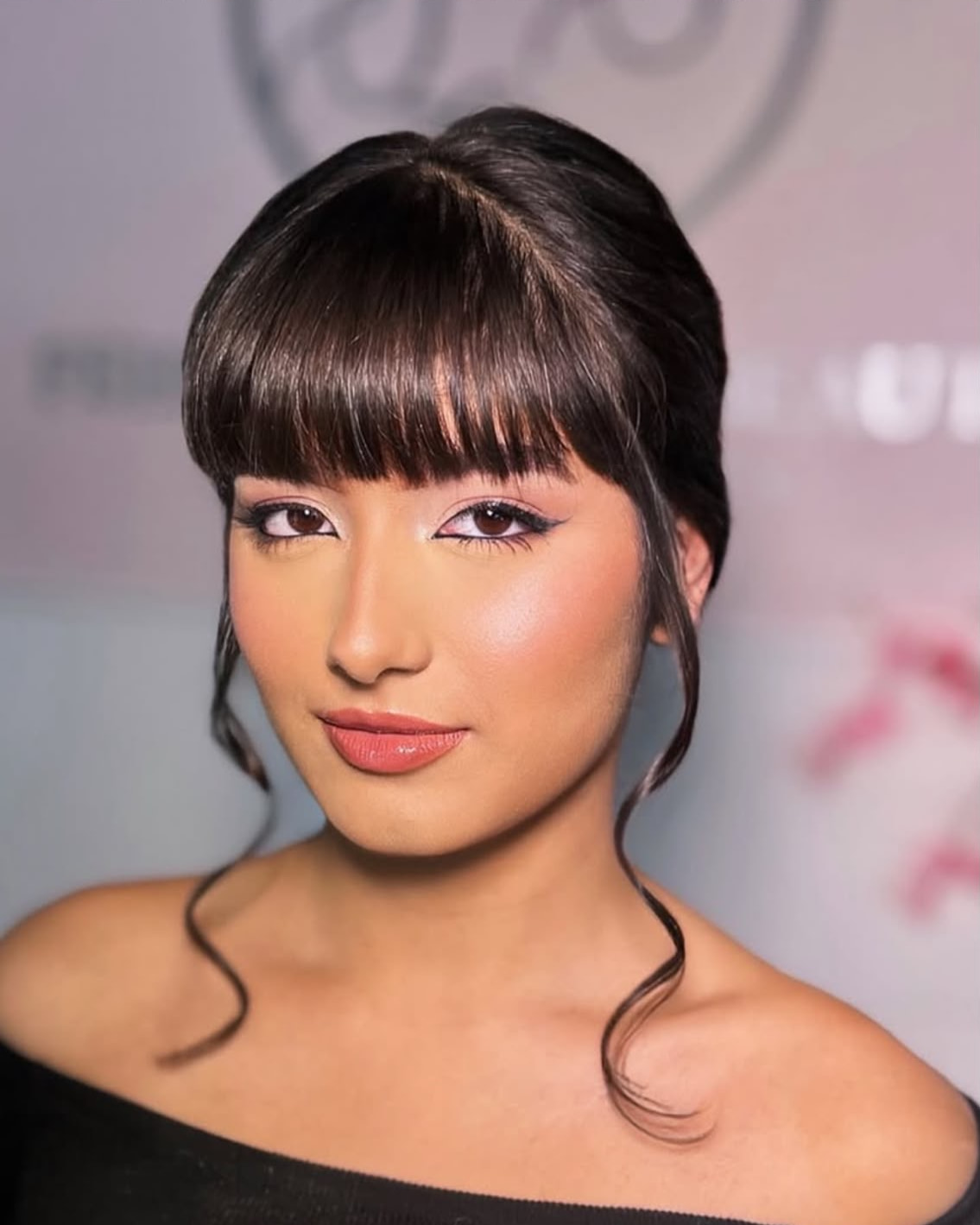 Julia Cardoso, maquiadora da Julia Studio Makeup, de franja e cabelo preso, com leve sorriso