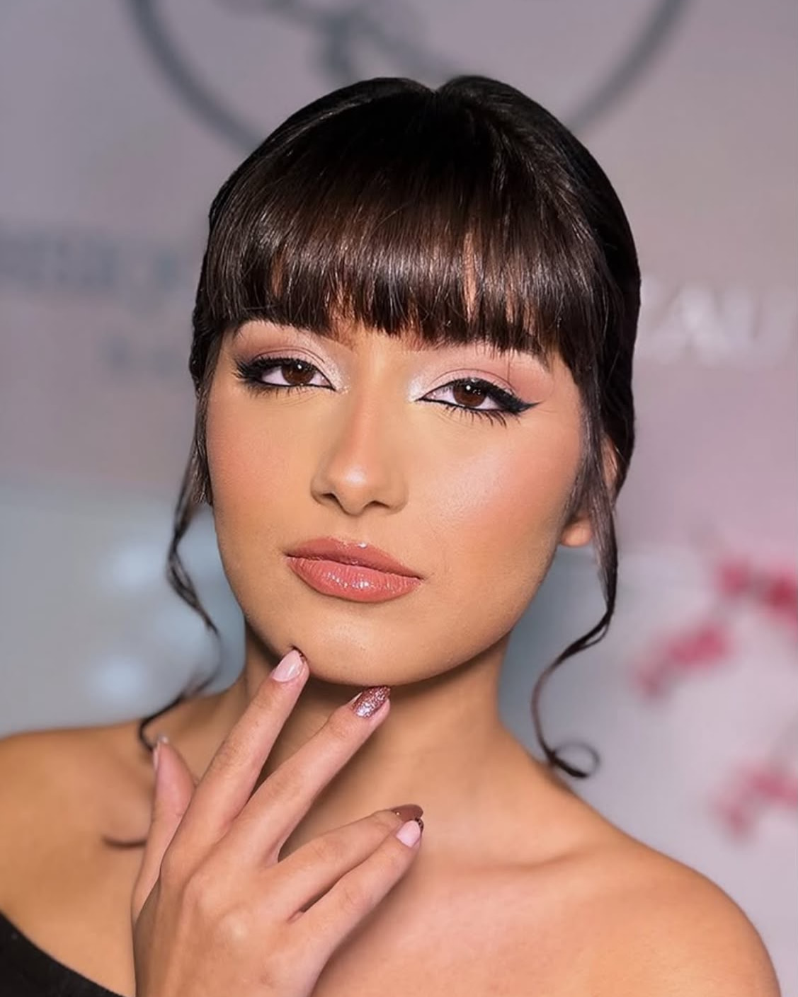 Julia Cardoso com a mão no queixo, de delineado gatinho e boca nude
